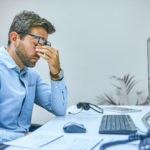 Cropped shot of a businessman looking exhausted while sitting at his desk