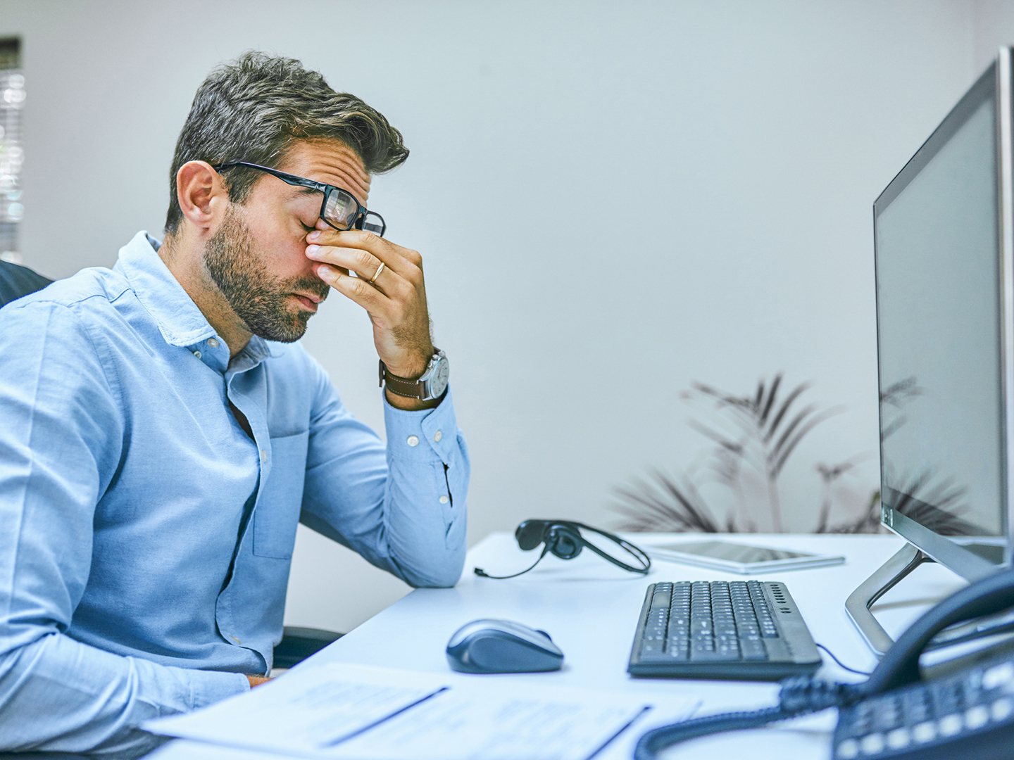 Cropped shot of a businessman looking exhausted while sitting at his desk