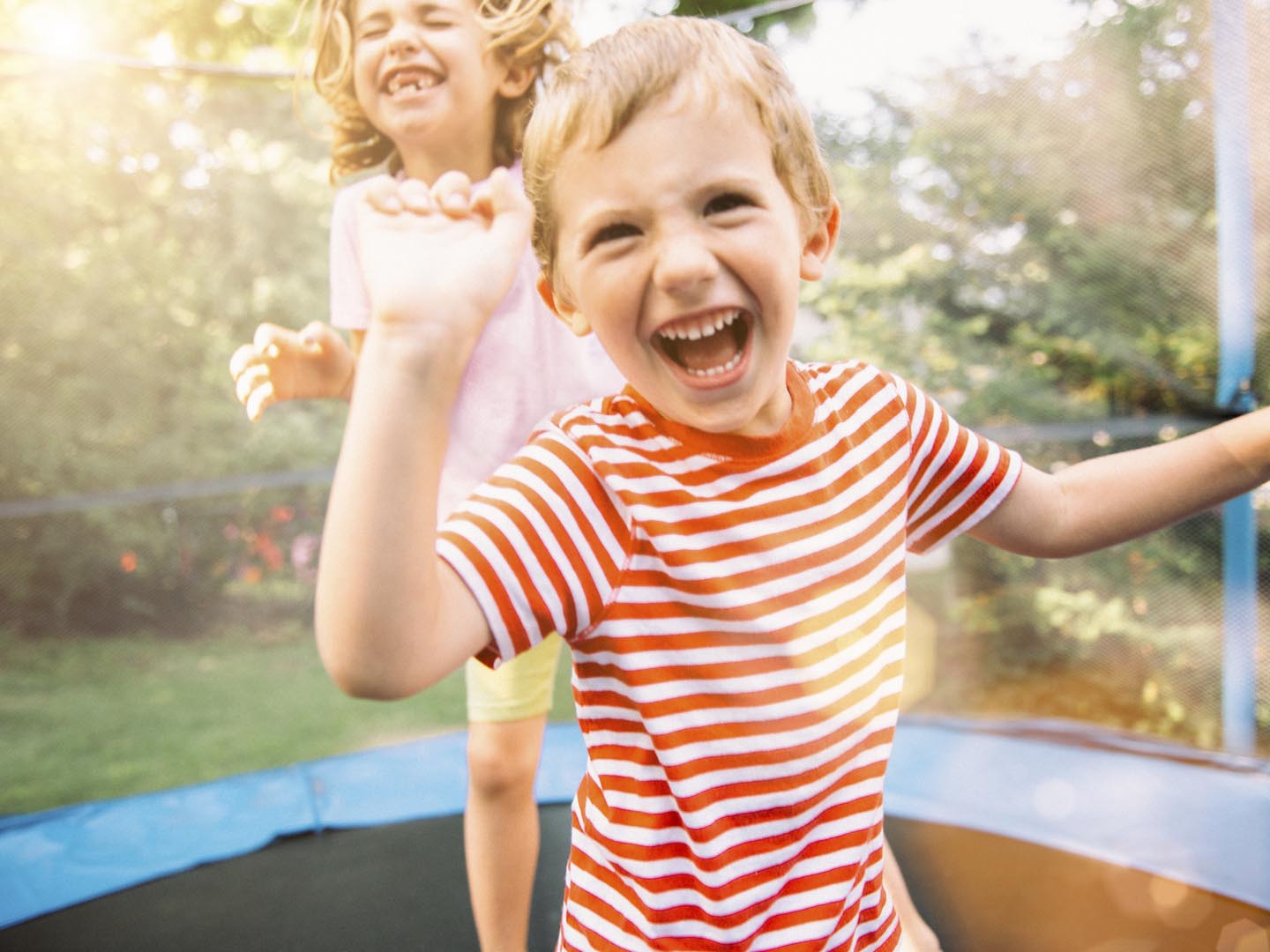 Children having fun on summer vacation jumping on trampoline