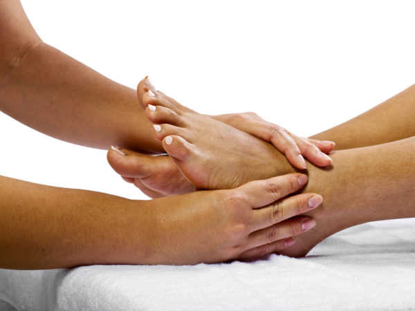 Young African American woman getting a foot massage and isolated on a white background